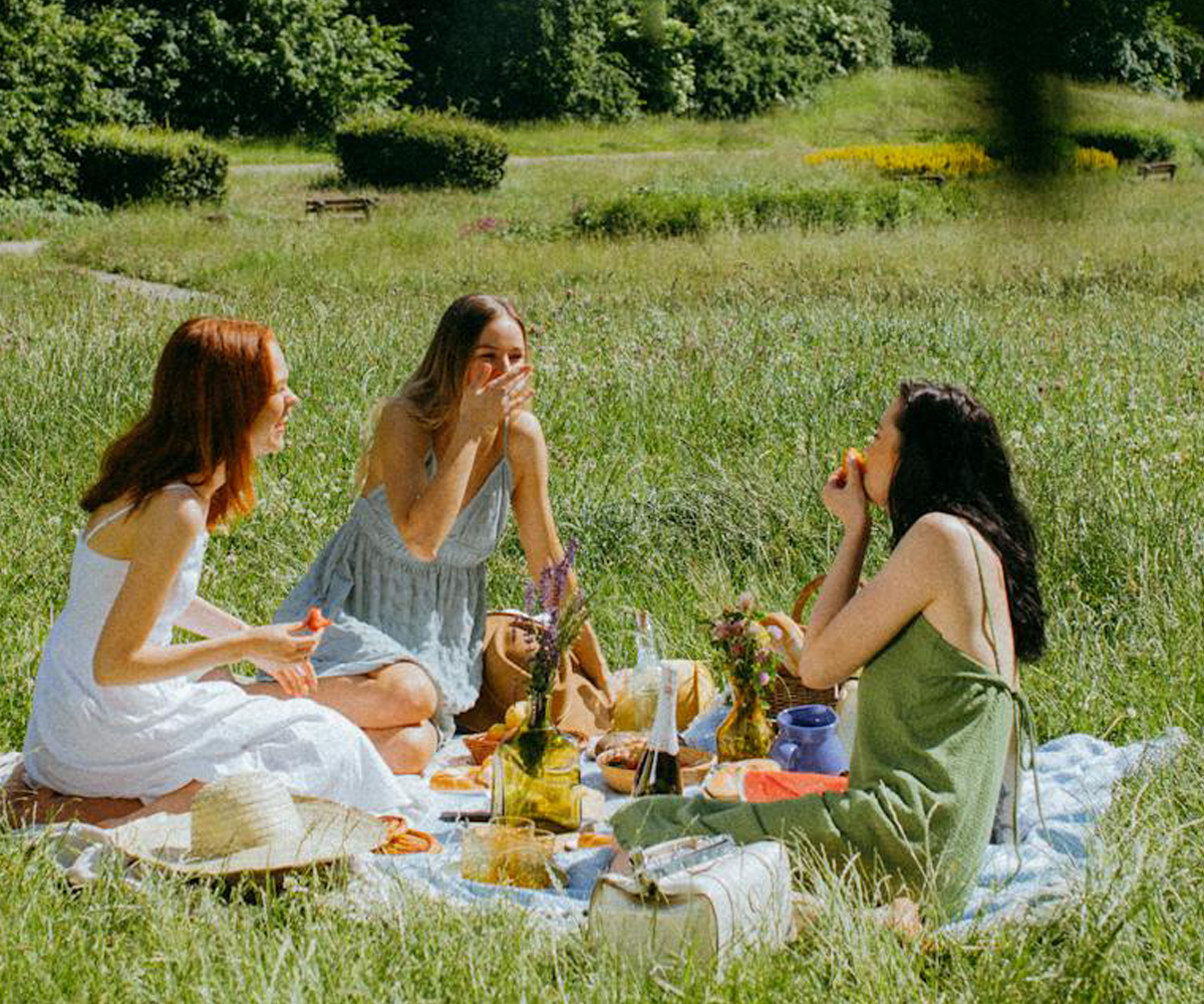 A group of friends sitting on the grass on a summer day.