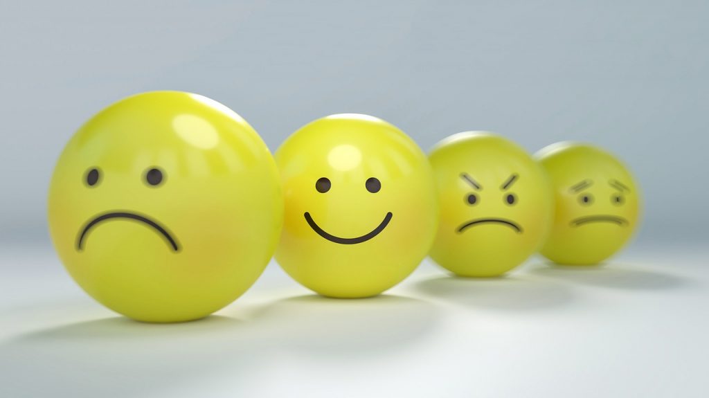 photo of a series of yellow balls with sad, happy, and other emotional faces
