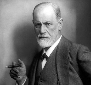 Sigmund Freud, a white man appearing here in his 60s, holding a cigar and wearing a three-piece suit.