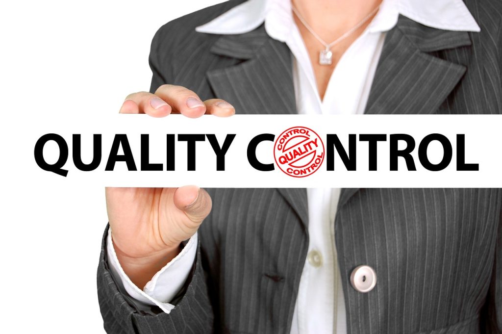 Business person behind sign showing "Quality Control"