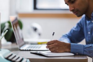 Student writing in notebook while studying