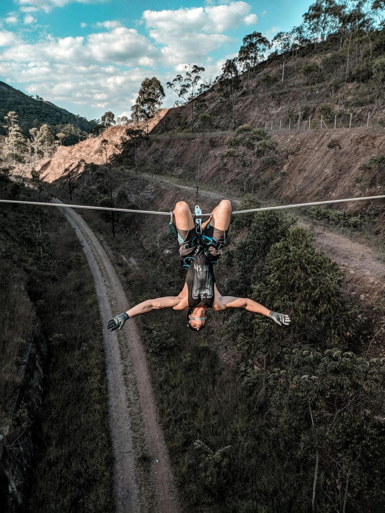 Man hanging upside down on zip line