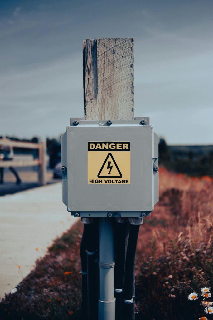 An electrical box on the side of a walkway labelled as electrical danger