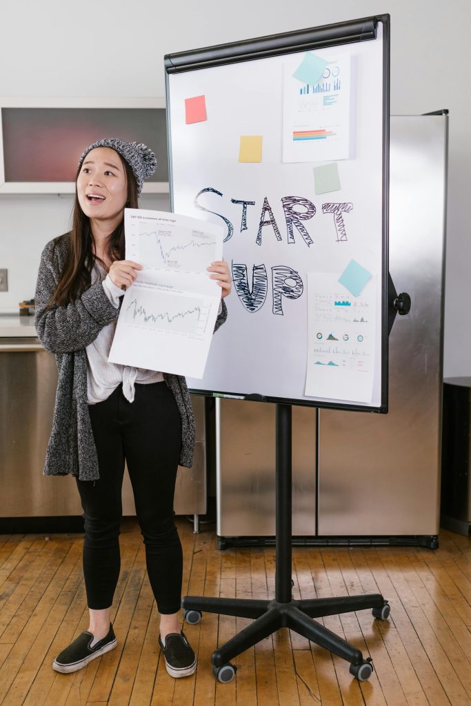 Entrepreneur pitching her ideas with a white board showing the words start up