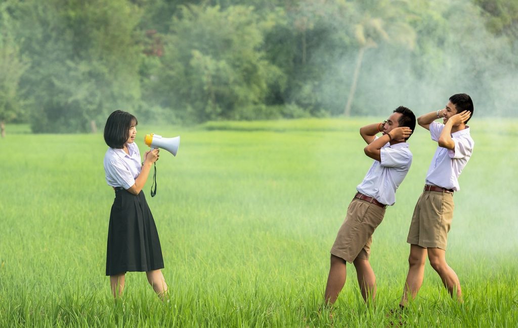 One person using a megaphone to communicate with two other people close by.