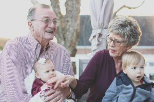 Grandparents holding their two young grandchildren.
