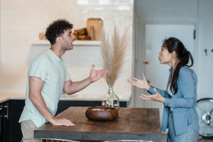 Husband and wife arguing in kitchen.