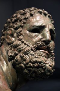 Image of Greek statue called boxer at rest. Head of a man with a beard, he has cauliflower ear.