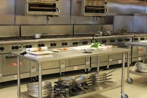 An industrial kitchen with an adjustable table/prep surface.