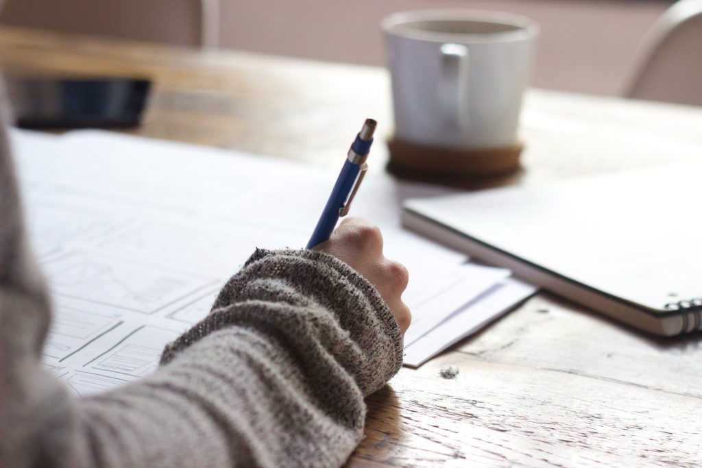 Student writing at a desk.