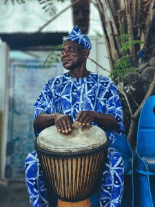 Elderly man playing traditional Djembe