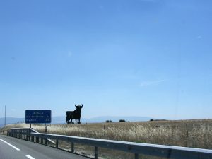 Sculpture du taureau Osborne en métal noir, visible depuis l’autoroute près de Madrid sous un ciel bleu dégagé.