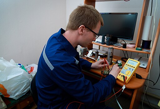 Man in overalls testing a circuit