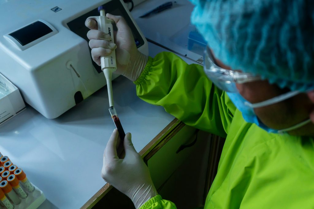 Health worker pipetting blood from test tube