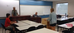 Asfrah in her classroom with students and courtroom furniture