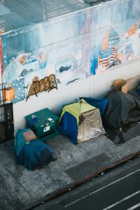 Homeless encampment containing tents along a wall