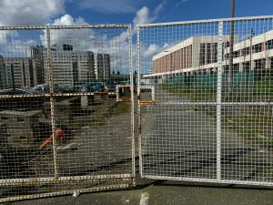A fence blocking entry to a building complex.