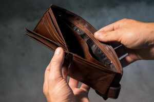 A person holding an empty wallet wide open