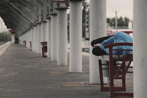Youth sleeping on a bench near a railway station