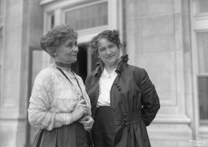 Two women standing outside a house