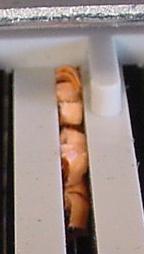 A gap between bars filled with little pieces of paper (chads)