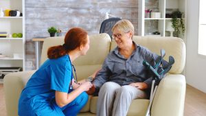 Female nurse talking with old woman with alzheimer