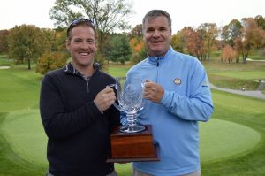 Two golfers holding an award.