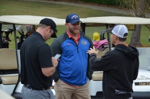 Golfers taking to each other on a golf course.