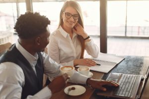 Two business colleagues sharing coffee while working.