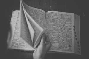 Image of a hand flipping through a dictionary