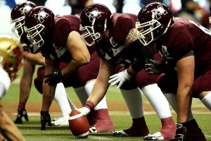 Football players getting ready to put the ball into play.