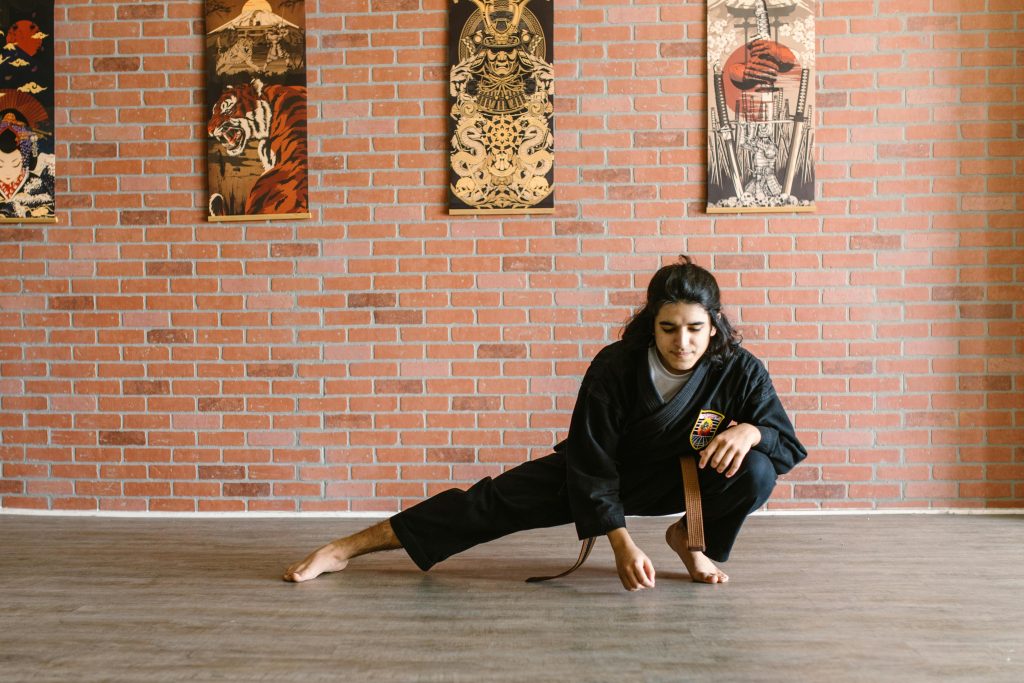 Photo of a martial arts professional in a pose that is low to the ground.