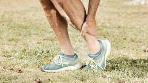 A person holding their lower leg in pain, suggesting a muscle cramp.