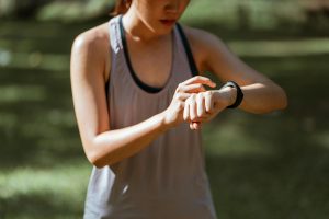 A person checking their heart rate while they run.