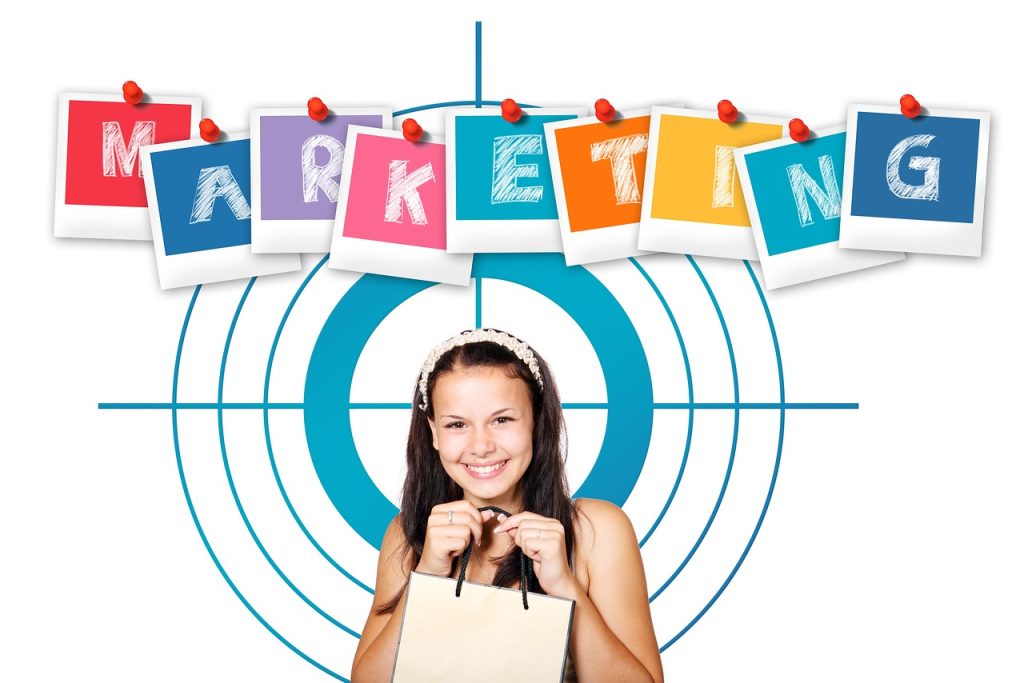 Young woman holding shopping bag with a target behind her, the word Marketing appears above with each letter on a polaroid picture hanging from a string