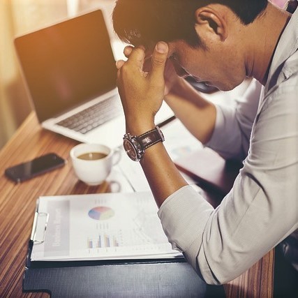 man with head in hands at work