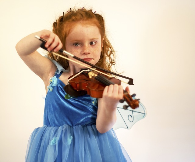 photo of a young child playing violin