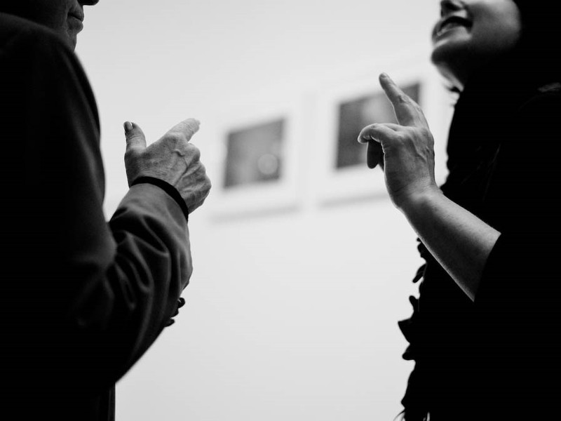 photo of two people pointing at eachother