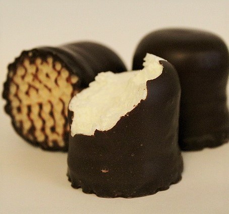 Photo of a chocolate covered marshmallow with a bite out of it 