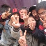 several children making peace signs with their hands