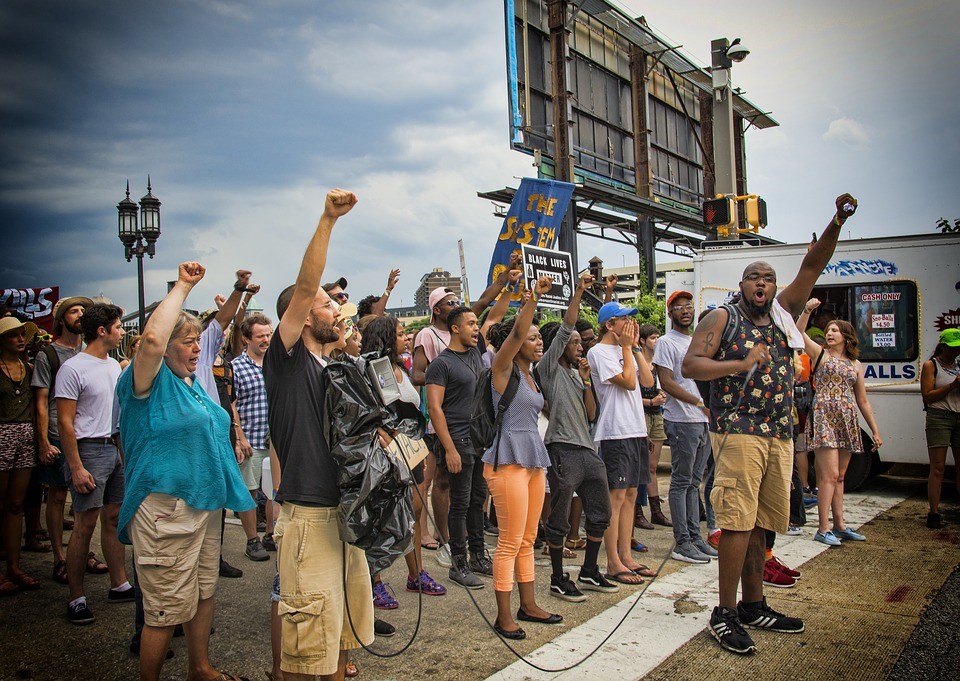 people with their fists raised at a protest on the street