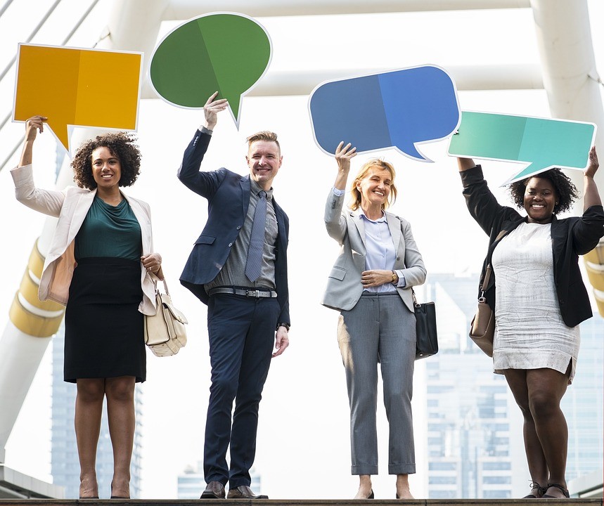 four people holding signs with speech bubbles over their head