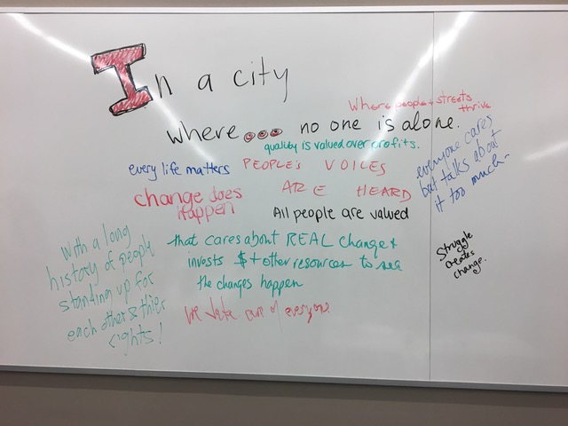 Whiteboard with written responses to second part of fill-in-the-blank post-performance activity: "These are stories of people who…in a City where…"