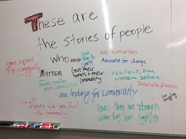 Whiteboard with written responses to first part of fill-in-the-blank post-performance activity: "These are stories of people who…in a City where…"