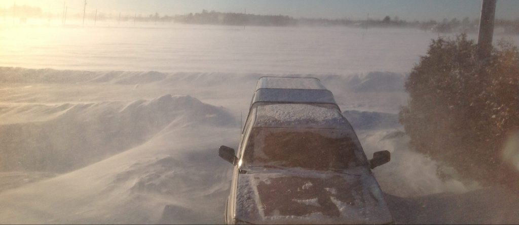 A photo of a snowed-in driveway and truck.