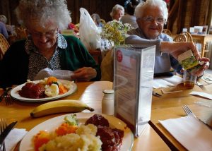 Two senior ladies enjoying roast beef dinner