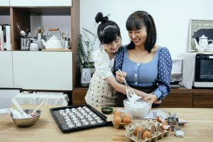 A mother and daughter baking meringues together